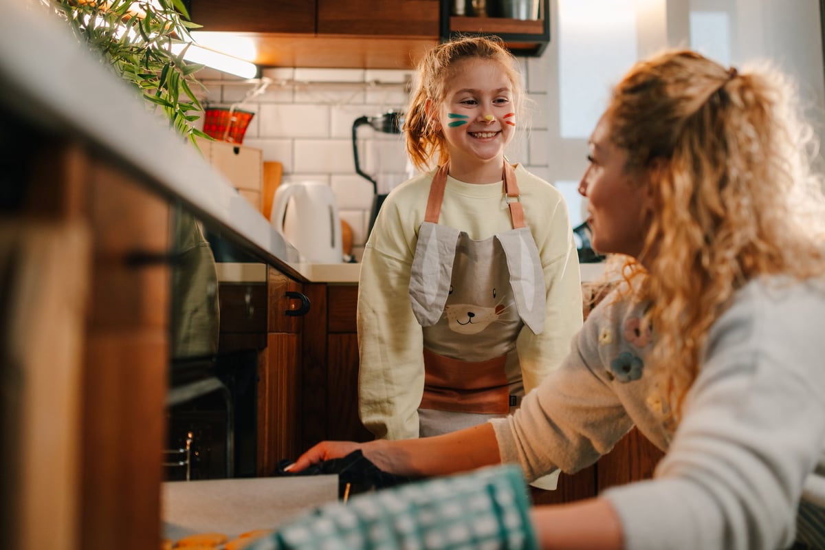 Mother and daughter baking cookies together in a modern kitchen