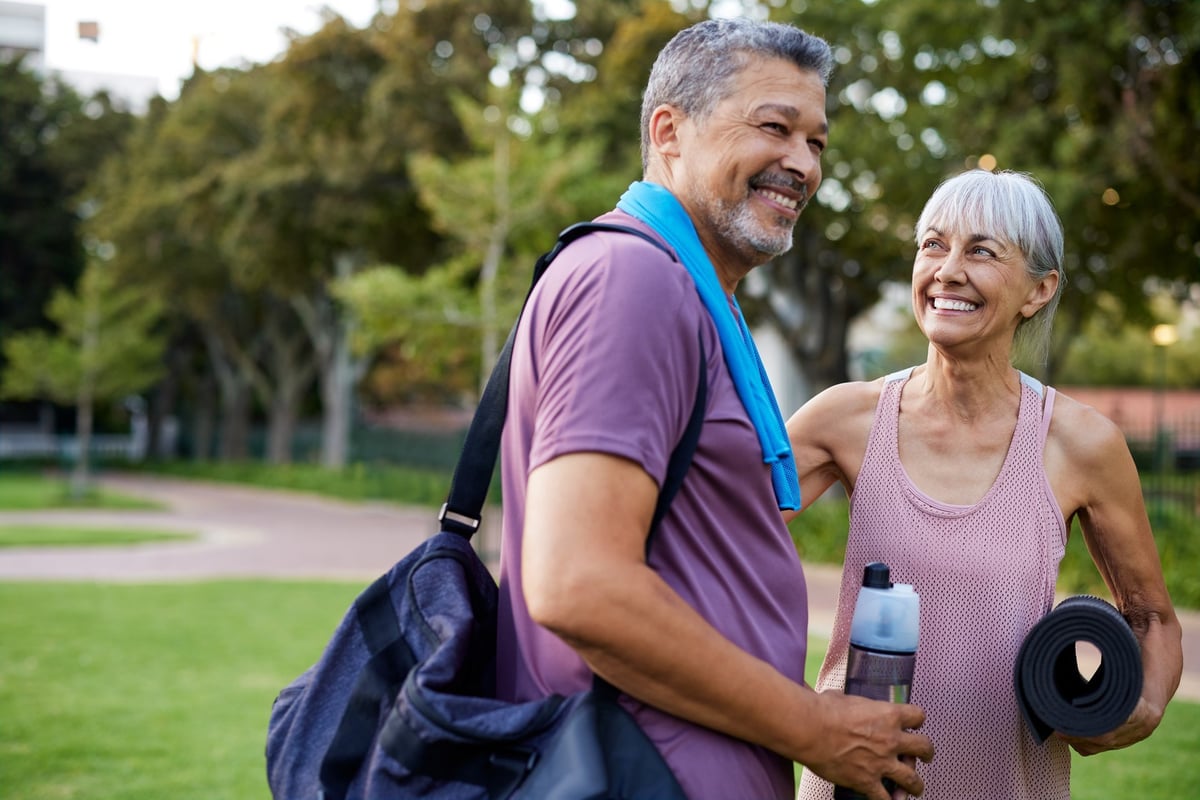 Mature couple smiling after a workout in the park, active lifestyle together