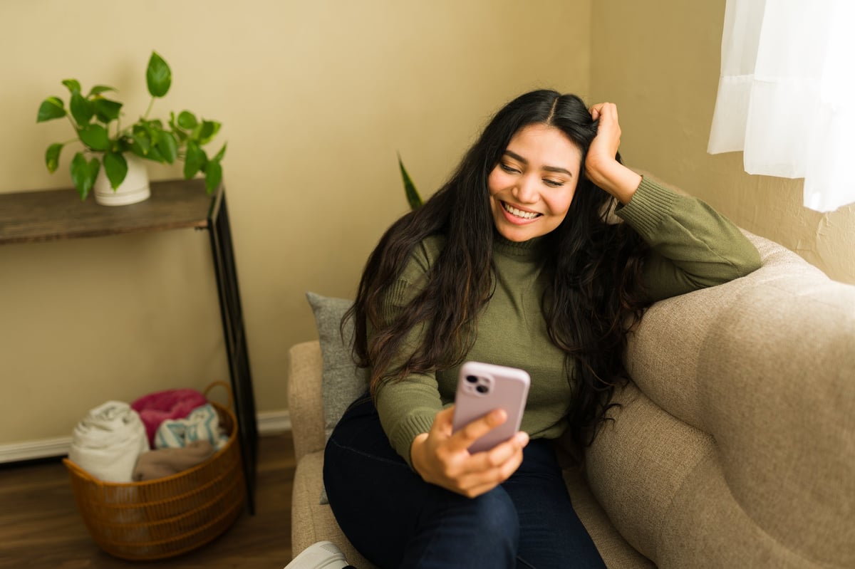 Smiling woman relaxing on a living room sofa