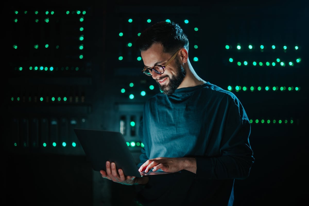 Smiling bearded man working on a laptop, focused and confident