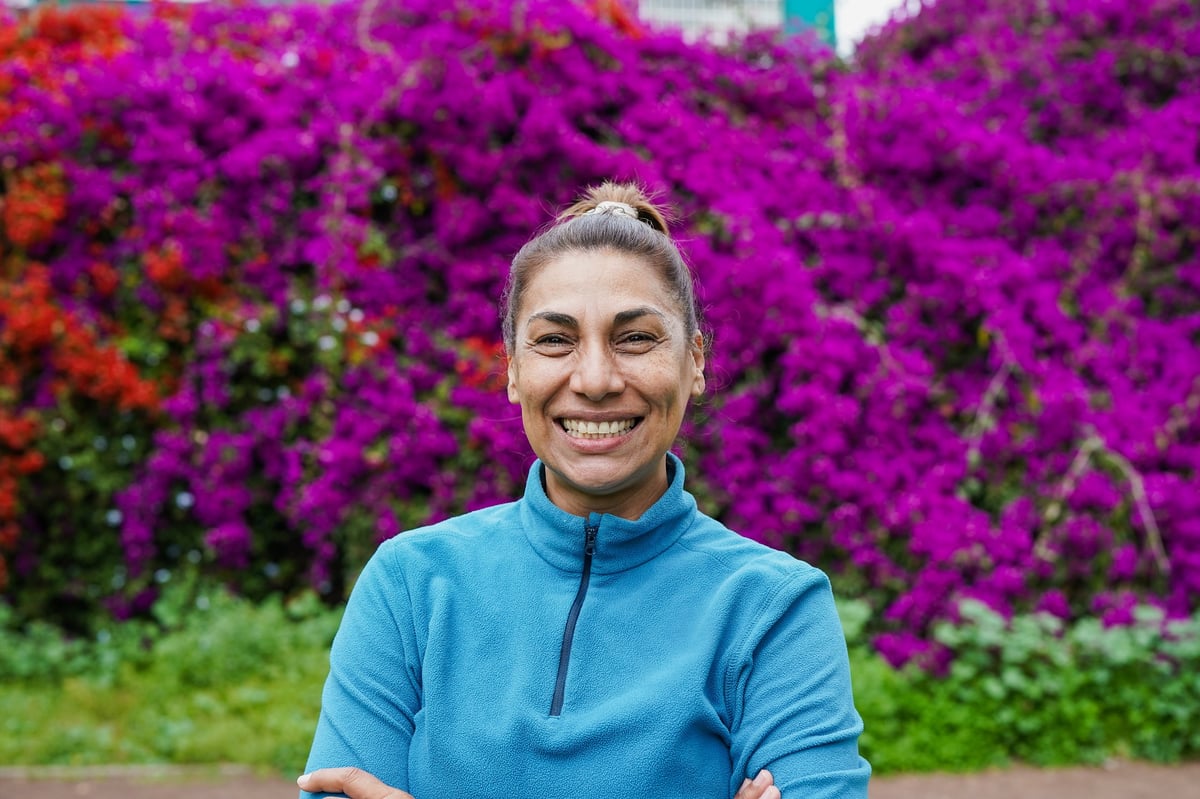 Portrait of a mature latin woman smiling outdoors, natural light, lifestyle and happiness concept